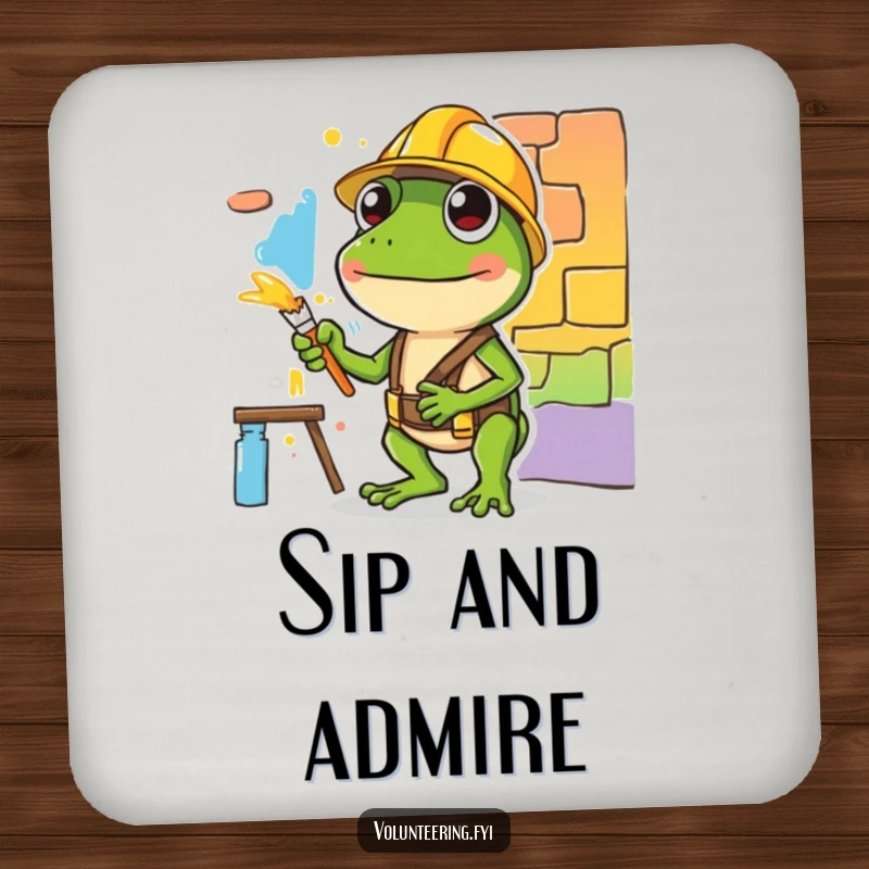 Funny coaster featuring a diligent green frog in a hard hat painting, symbolizing artistic dedication and humor.