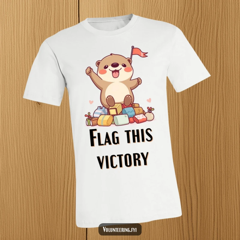 Funny t-shirt with a joyful otter proudly waving a flag from a mound of loot, ideal for a humorous apparel gift.