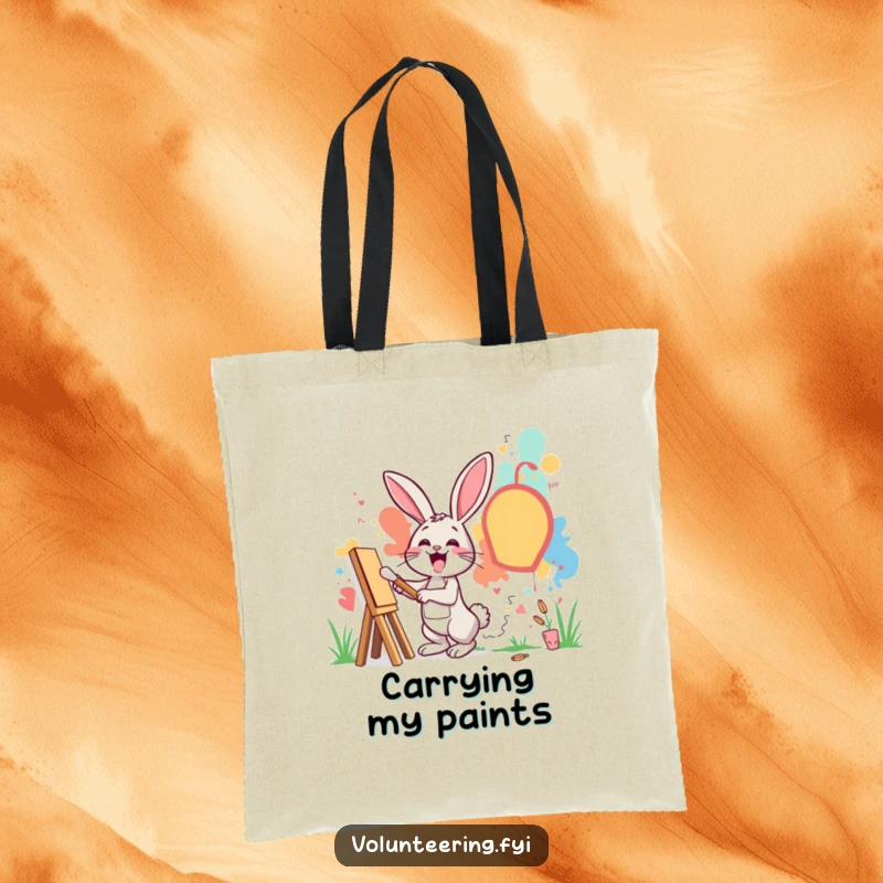 Funny tote bag with an excited rabbit painting a mural on a community wall, ideal for carrying art supplies.